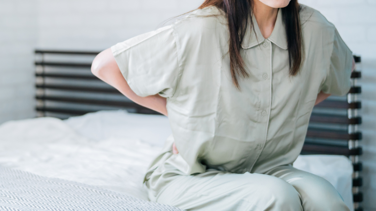 ベッドの上で腰痛に悩まされる女性