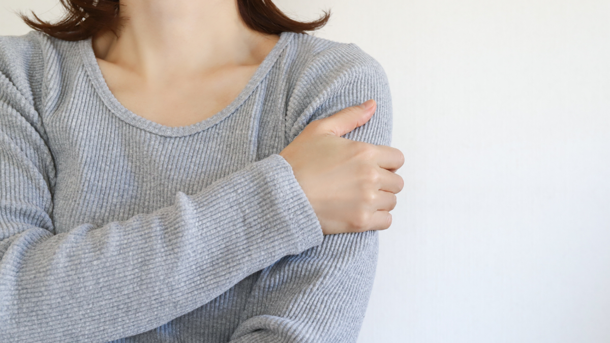 腕に痛みを感じている女性