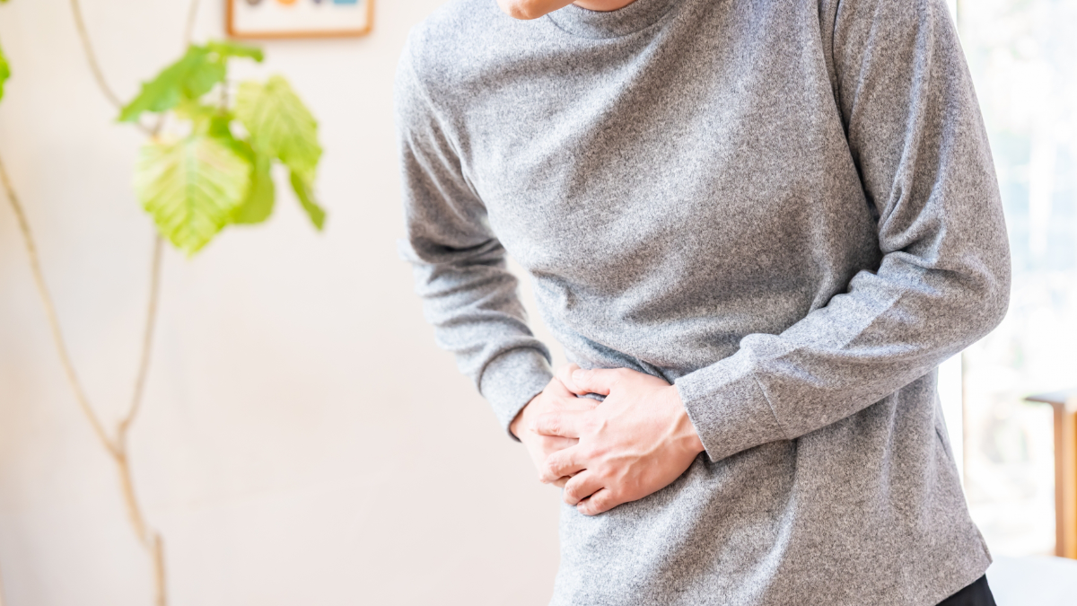 下腹部に痛みを感じている男性