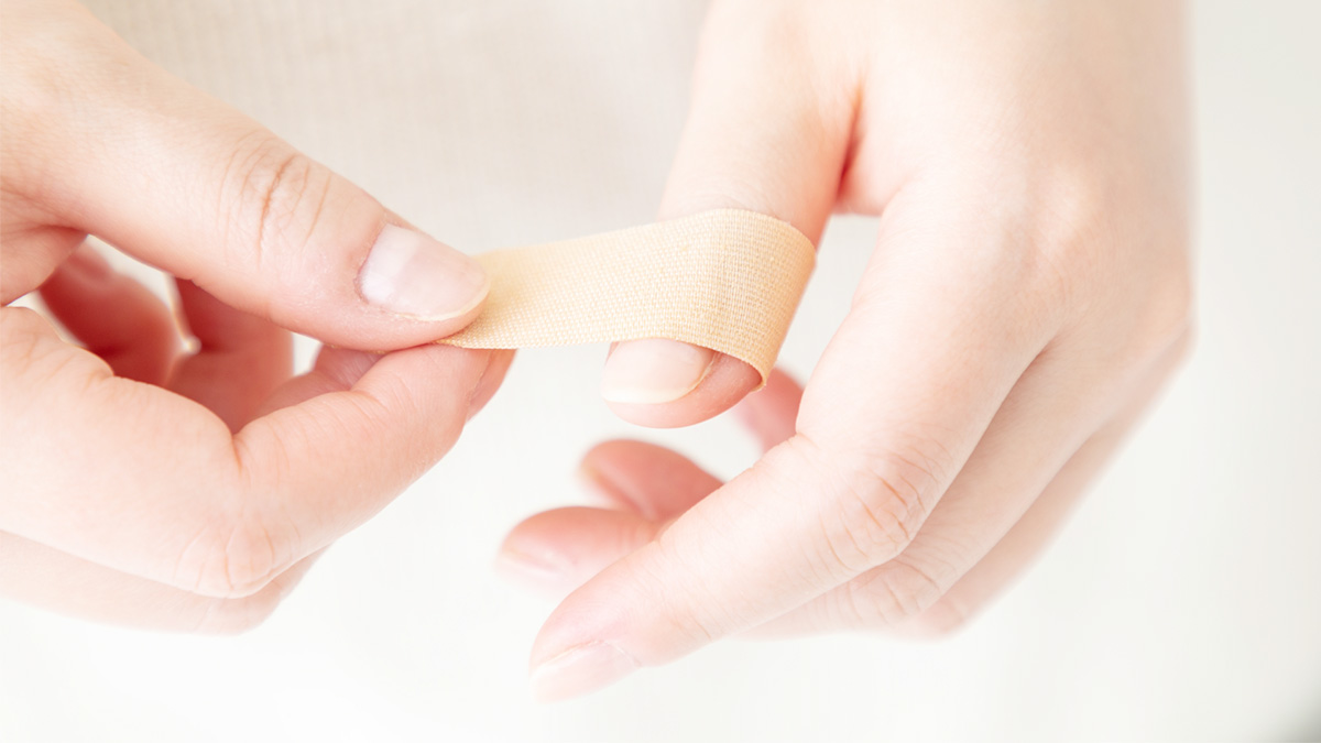 傷口に絆創膏を貼っているイメージ