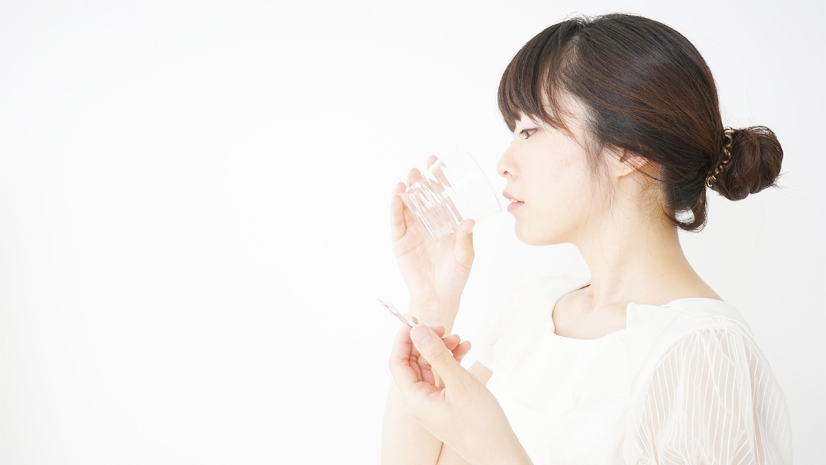 内服薬を飲んでいる女性